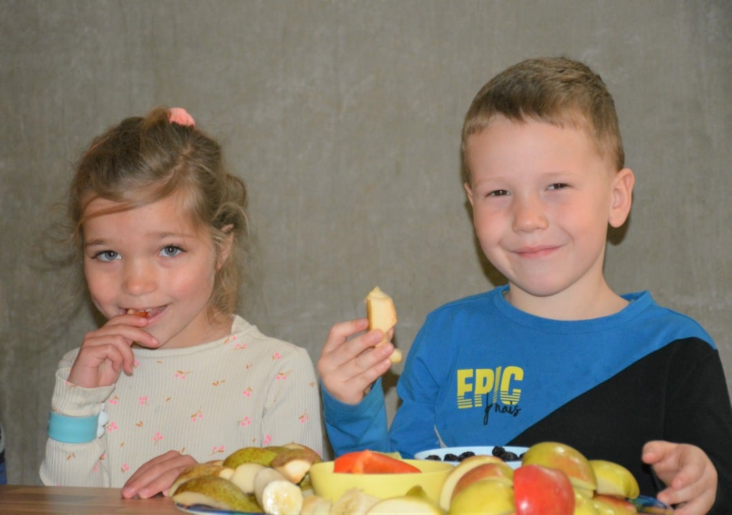 twee kinderen eten fruit