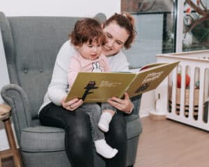 Pm'er leest een kindje voor uit een boek op KDV Uithoorn